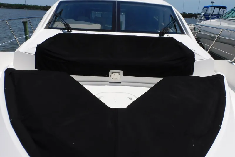 Slide: The Image of 2019 Sea Ray L550 yacht with black covers on deck, docked by the water. - 33