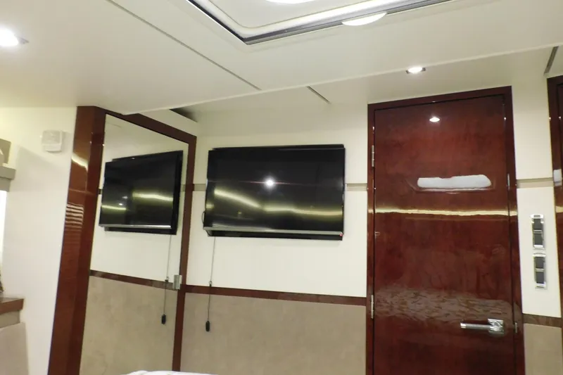 Slide: The Image of Luxurious interior of 2019 Sea Ray L550 yacht with mounted TV and polished wood finishes. - 40