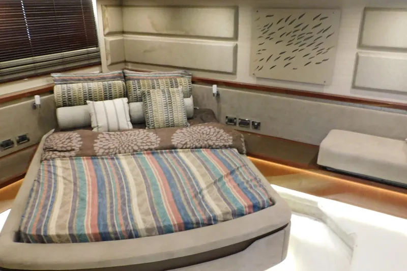 Slide: The Image of Luxurious 2019 Sea Ray L550 yacht bedroom with striped bedding and decorative pillows. - 52
