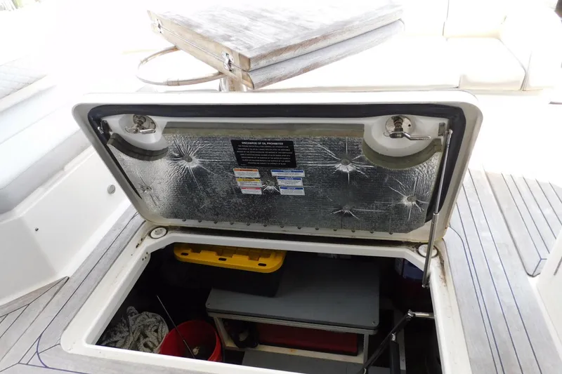 Slide: The Image of Open storage compartment on 2019 Sea Ray L550 yacht deck, showing interior contents. - 60