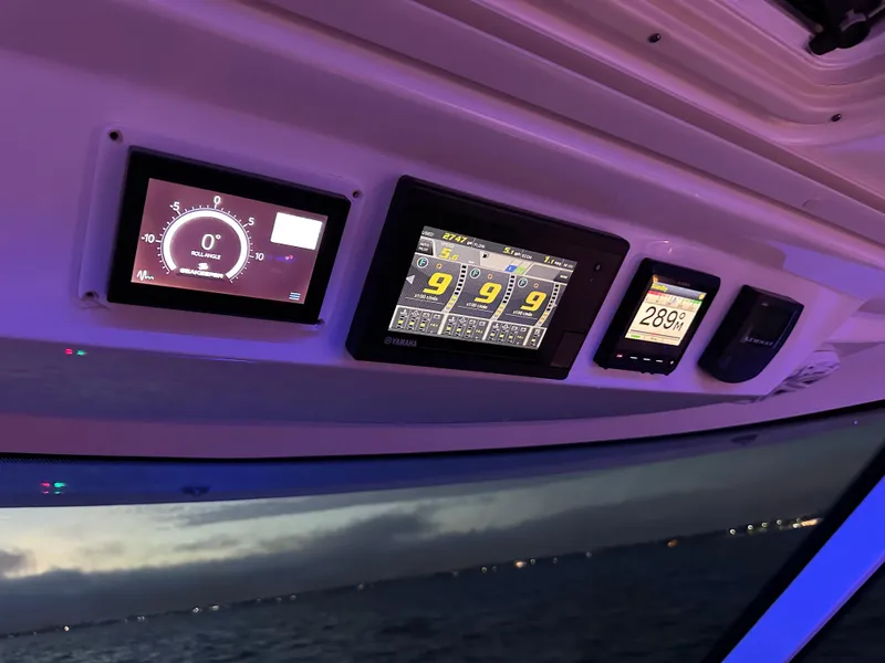 Slide: The Image of Dashboard of 2020 Tiara Yachts 43 LS with illuminated navigation screens at dusk. - 19