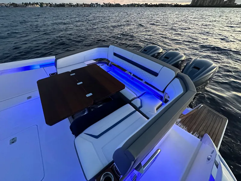 Slide: The Image of 2020 Tiara Yachts 43 LS with elegant seating and table, illuminated by blue LED lights. - 20