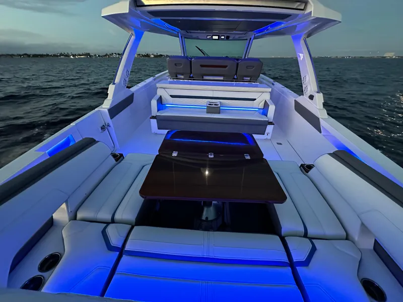 Slide: The Image of Luxurious 2020 Tiara Yachts 43 LS with blue LED lighting on open water. - 24
