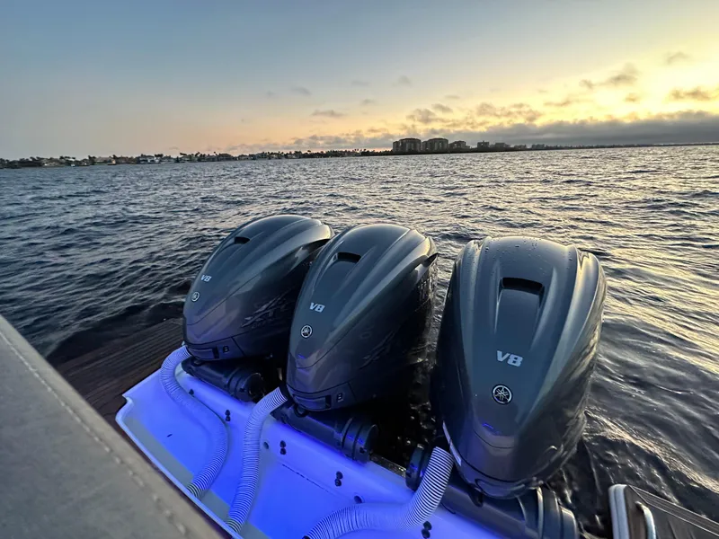 Slide: The Image of 2020 Tiara Yachts 43 LS with triple V8 engines at sunset on the water. - 25