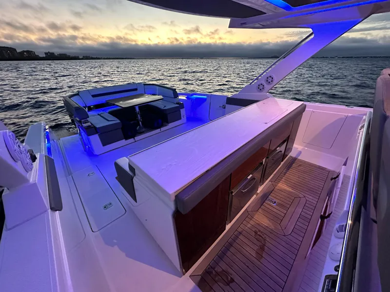Slide: The Image of 2020 Tiara Yachts 43 LS with elegant deck lighting at sunset on the water. - 29