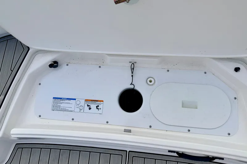 Slide: The Image of 2024 Yamaha AR195 boat storage compartment with safety instructions and drainage features. - 17
