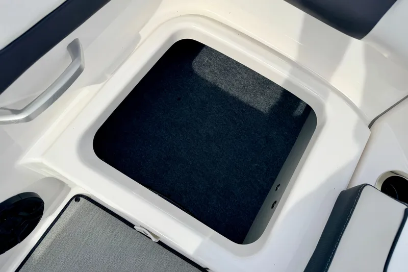 Slide: The Image of 2024 Yamaha AR195 boat storage compartment with carpeted interior and sleek design. - 23