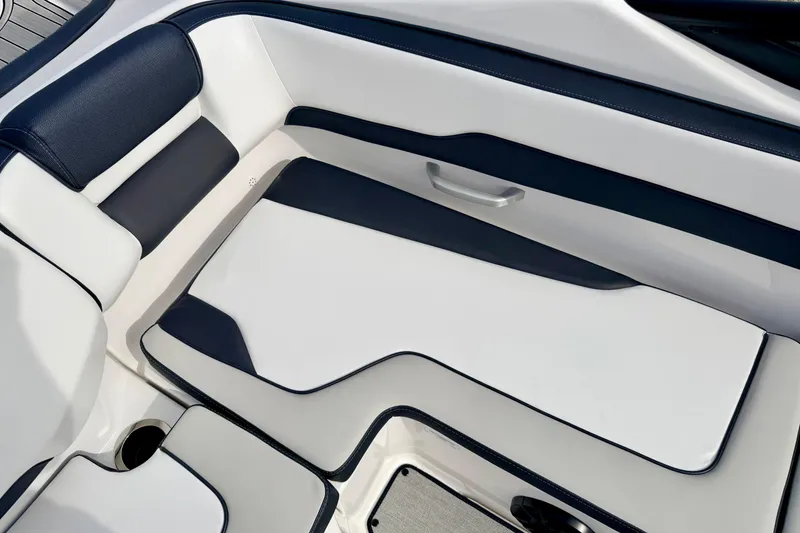 Slide: The Image of 2024 Yamaha AR195 boat interior with sleek white and navy seating design. - 24