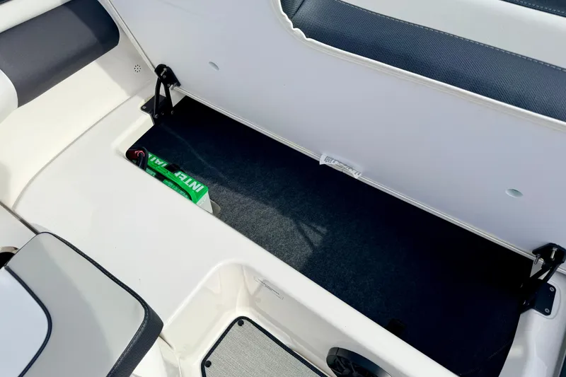Slide: The Image of 2024 Yamaha AR195 boat storage compartment with integrated battery and sleek interior design. - 25