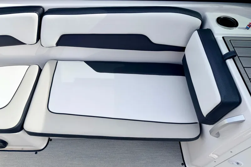 Slide: The Image of 2024 Yamaha AR195 boat seating with white and navy upholstery, featuring a cup holder. - 41