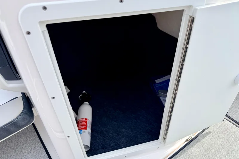 Slide: The Image of Open storage compartment on 2024 Yamaha AR195 boat with fire extinguisher inside. - 44