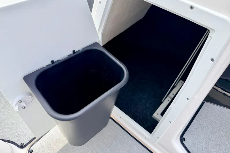 Slide: The Image of 2024 Yamaha AR195 boat interior storage compartment with trash bin. - 46