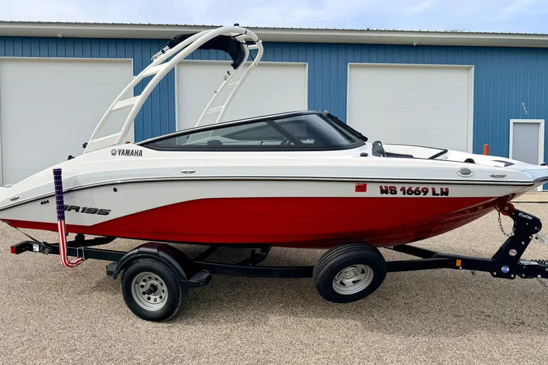 Slide: The Image of 2024 Yamaha AR195 boat with red and white design on a trailer. - 5