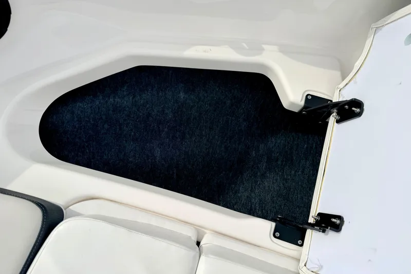 Slide: The Image of 2024 Yamaha AR195 boat interior storage compartment with white and black trim. - 53