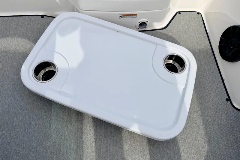 Slide: The Image of 2024 Yamaha AR195 boat table with cup holders on gray carpeted deck. - 62