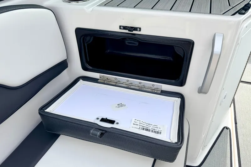 Slide: The Image of 2024 Yamaha AR195 boat storage compartment with open hatch and visible interior. - 63
