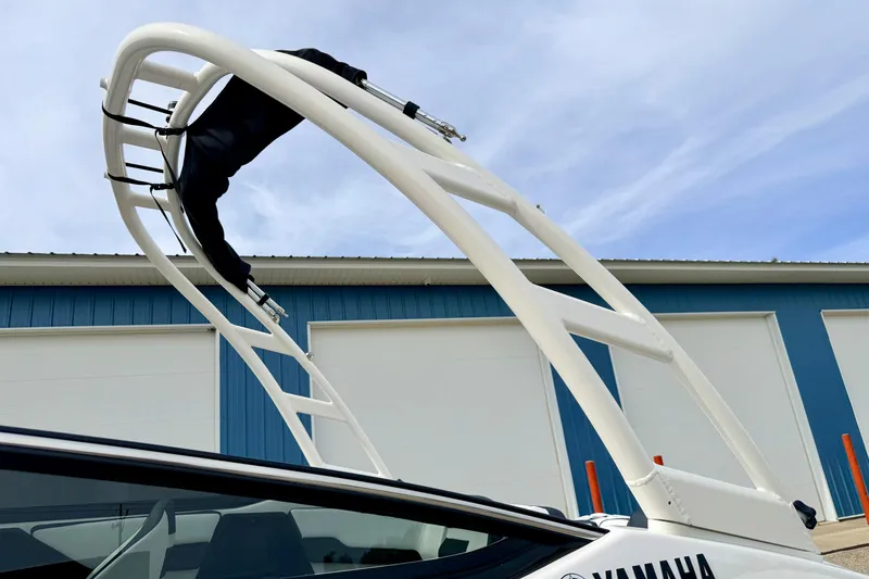 Slide: The Image of 2024 Yamaha AR195 boat with sleek wakeboard tower against blue sky. - 66