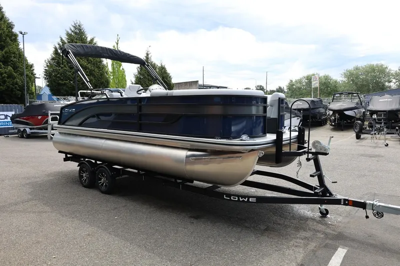 Slide: The Image of 2026 Lowe SS 210 CL pontoon boat on trailer, displayed outdoors in a dealership lot. - 11