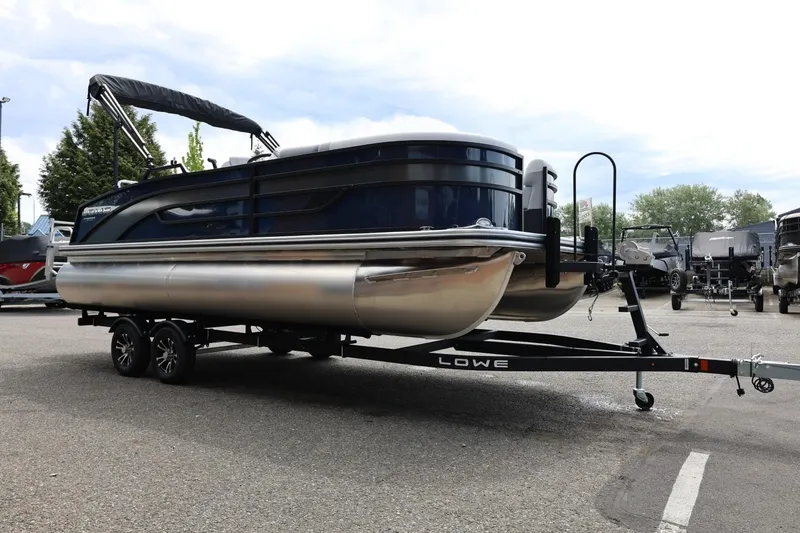 Slide: The Image of 2026 Lowe SS 210 CL pontoon boat on trailer in parking lot. - 12