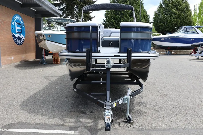 Slide: The Image of 2026 Lowe SS 210 CL pontoon boat on trailer at Bjornson Marine dealership. - 13