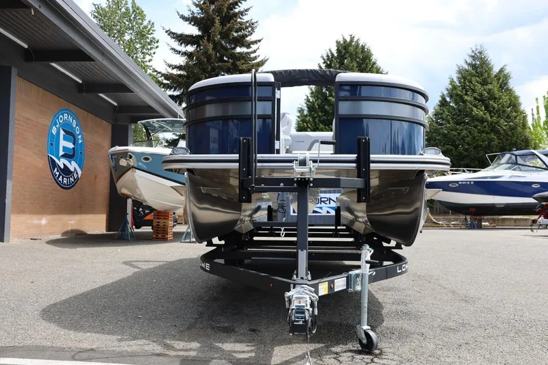 Slide: The Image of 2026 Lowe SS 210 CL pontoon boat on trailer at Bjornson Marine dealership. - 14
