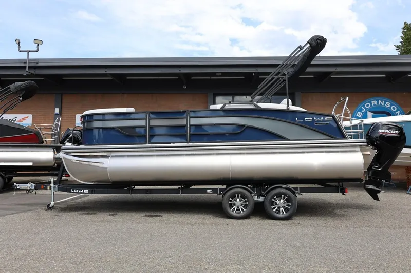 Slide: The Image of 2026 Lowe SS 210 CL pontoon boat on trailer, featuring Mercury outboard motor. - 2