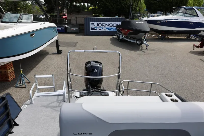 Slide: The Image of 2026 Lowe SS 210 CL boat at marina with outboard motor and other boats nearby. - 32