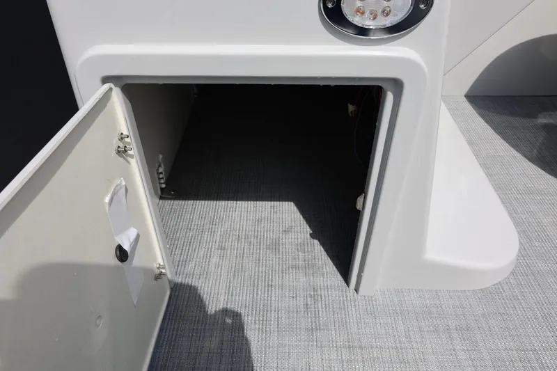 Slide: The Image of Open storage compartment on 2026 Lowe SS 210 CL boat, featuring gray flooring and lighting. - 37