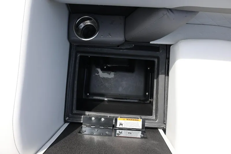 Slide: The Image of Storage compartment in 2026 Lowe SS 210 CL boat with cup holder and warning label. - 40