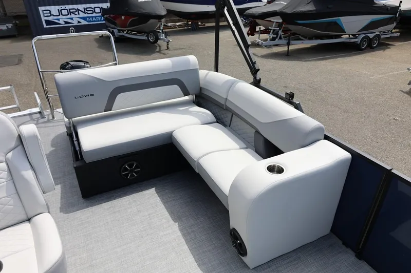 Slide: The Image of 2026 Lowe SS 210 CL pontoon boat interior with plush seating and cup holder. - 44