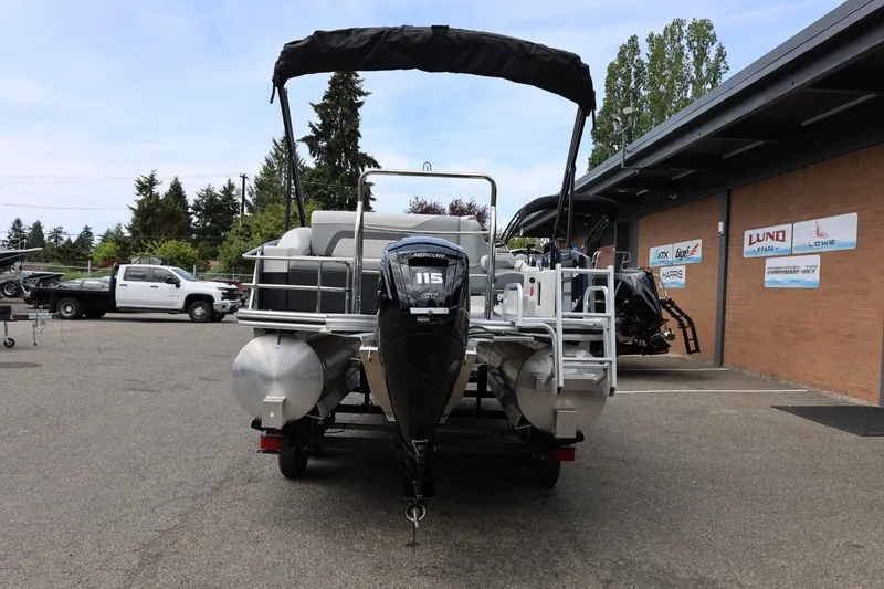 Slide: The Image of 2026 Lowe SS 210 CL pontoon boat with Mercury 115 engine, parked outdoors. - 5