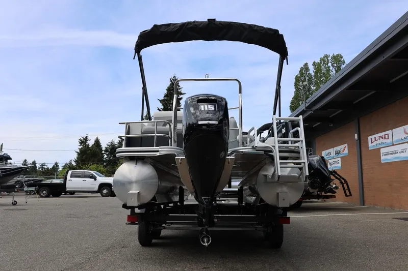 Slide: The Image of 2026 Lowe SS 210 CL pontoon boat with Mercury 115 engine, parked outdoors. - 6