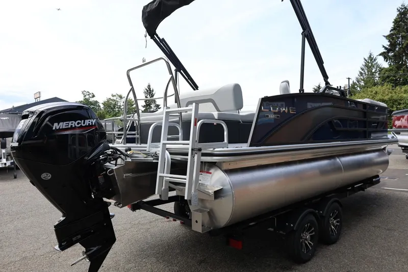 Slide: The Image of 2026 Lowe SS 210 CL pontoon boat with Mercury outboard motor, parked on a trailer. - 7