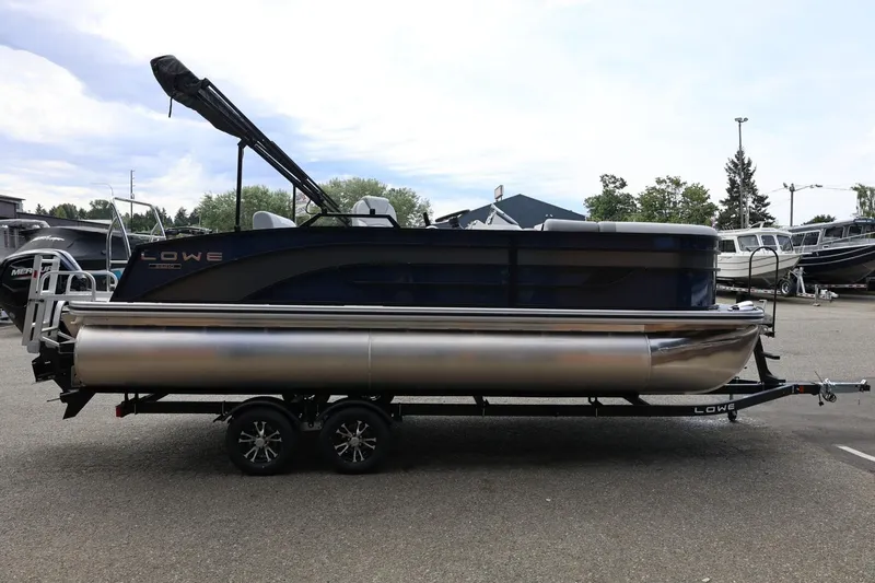 Slide: The Image of 2026 Lowe SS 210 CL pontoon boat on trailer in outdoor setting. - 9
