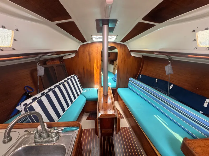 Slide: The Image of Interior of a 1988 Beneteau First 285 yacht with blue cushions. - 16