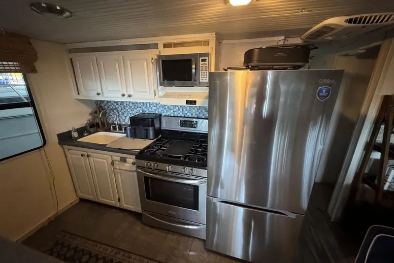 Slide: The Image of Kitchen interior of 2006 Catamaran Cruisers Aqua Cruiser Executive, featuring modern appliances. - 15