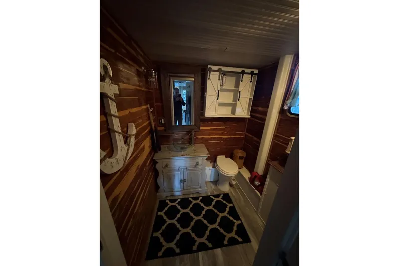 Slide: The Image of Bathroom interior of 2006 Catamaran Cruisers Aqua Cruiser Executive, featuring wood paneling and nautical decor. - 16