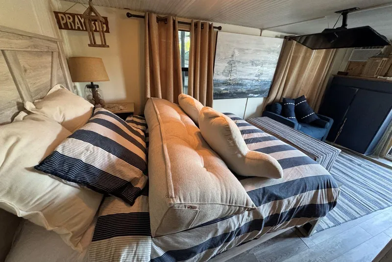 Slide: The Image of Interior of 2006 Catamaran Cruisers Aqua Cruiser Executive, featuring cozy bedroom with striped bedding. - 19