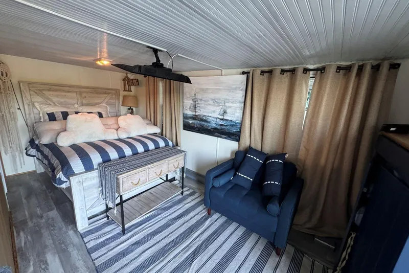 Slide: The Image of Cozy bedroom in 2006 Catamaran Cruisers Aqua Cruiser Executive, featuring nautical decor and striped bedding. - 21