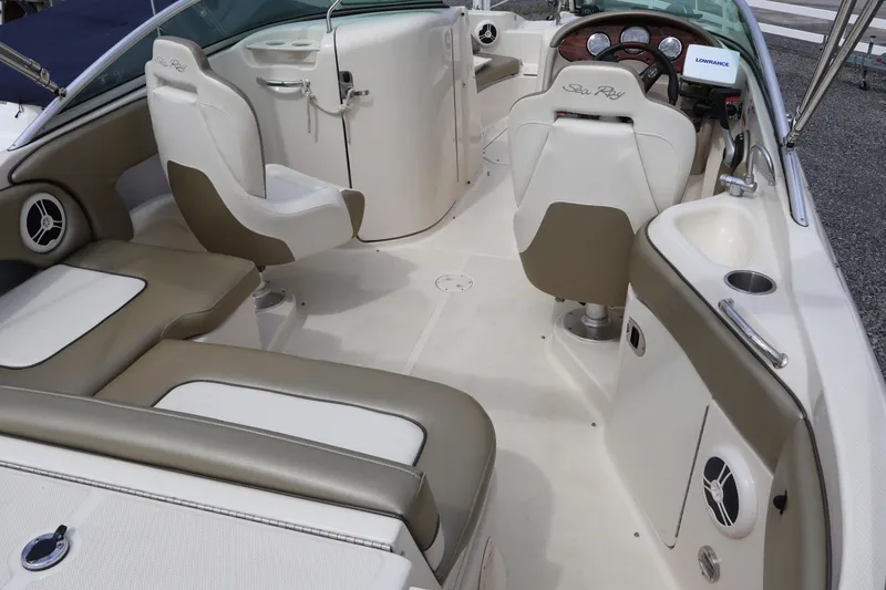 Slide: The Image of 2007 Sea Ray 220 Sundeck interior with beige seating and steering console. - 11