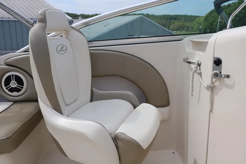 Slide: The Image of 2007 Sea Ray 220 Sundeck interior with white and beige seating, speaker, and rope detail. - 19