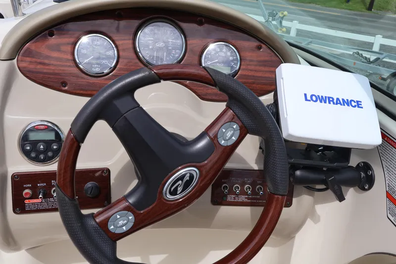 Slide: The Image of Dashboard of 2007 Sea Ray 220 Sundeck with steering wheel and Lowrance device. - 24