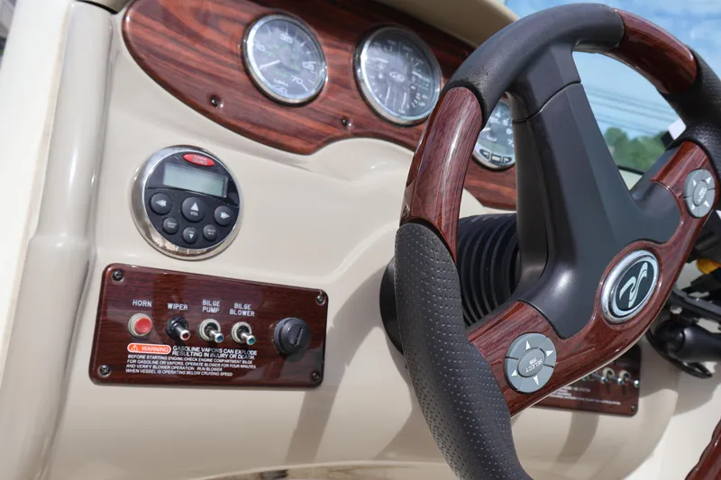 Slide: The Image of Steering wheel and dashboard of 2007 Sea Ray 220 Sundeck boat, featuring wood accents and controls. - 25