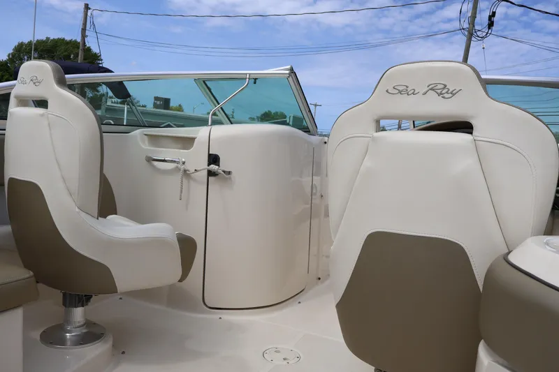 Slide: The Image of 2007 Sea Ray 220 Sundeck interior with white and beige seating, clear windshield. - 29