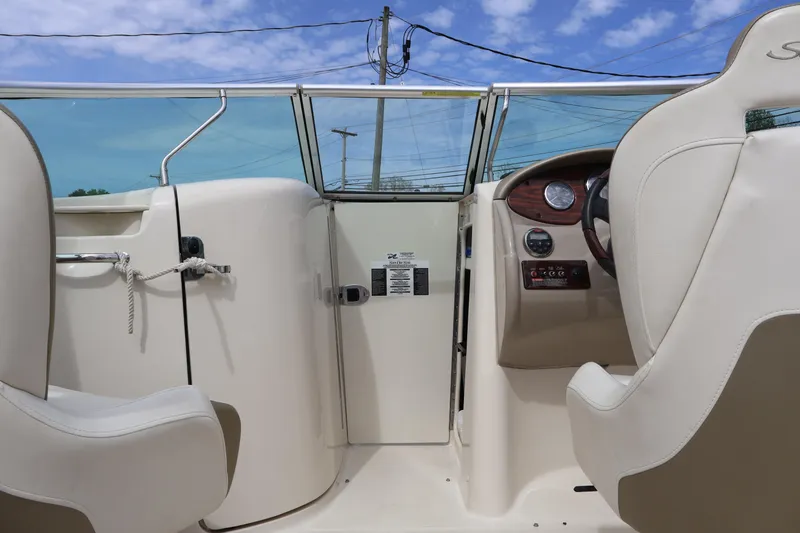 Slide: The Image of 2007 Sea Ray 220 Sundeck interior with steering wheel and seating under blue sky. - 32
