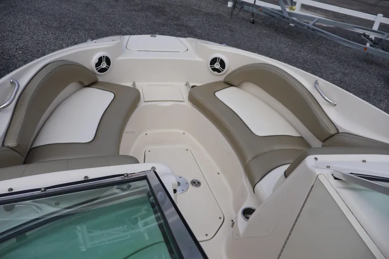 Slide: The Image of 2007 Sea Ray 220 Sundeck interior with beige and white seating, showcasing spacious bow area. - 33