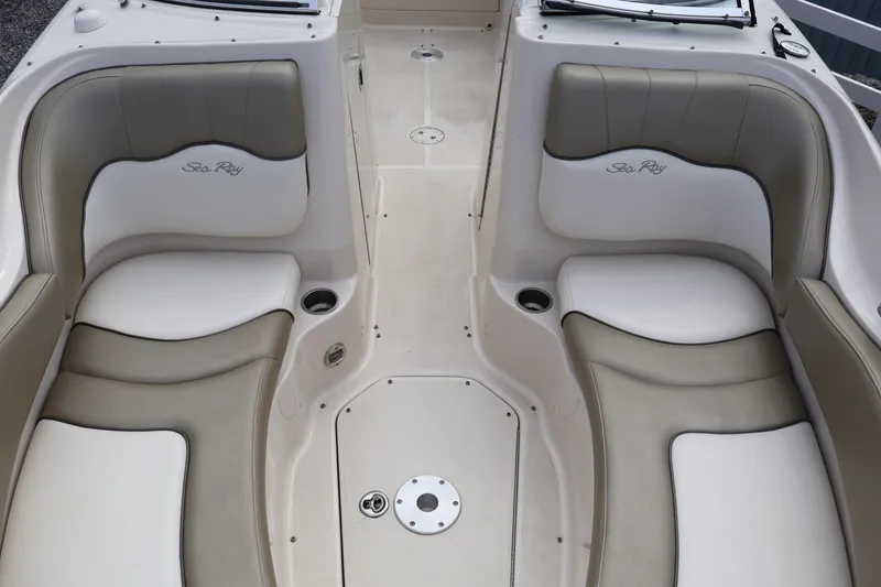 Slide: The Image of 2007 Sea Ray 220 Sundeck interior with beige and white seating, cup holders, and logo. - 34