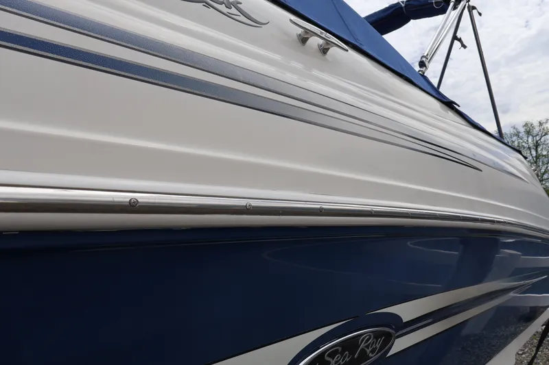 Slide: The Image of 2007 Sea Ray 220 Sundeck boat with blue and white exterior detailing. - 57