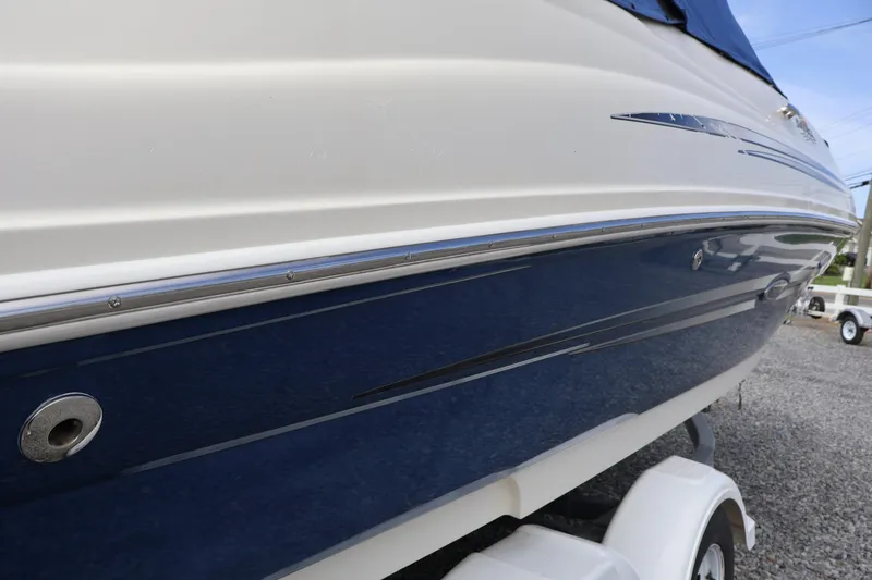 Slide: The Image of 2007 Sea Ray 220 Sundeck boat side view, featuring sleek blue and white design. - 58