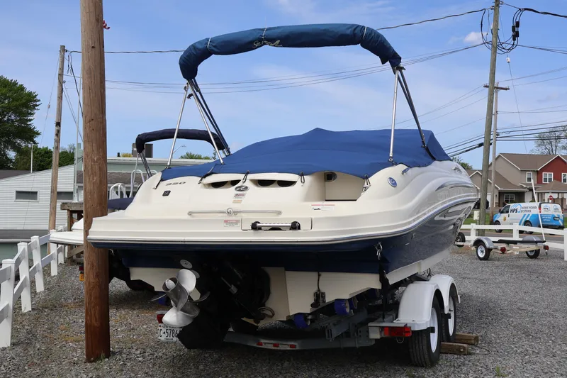Slide: The Image of 2007 Sea Ray 220 Sundeck boat on trailer, covered and parked outdoors. - 7